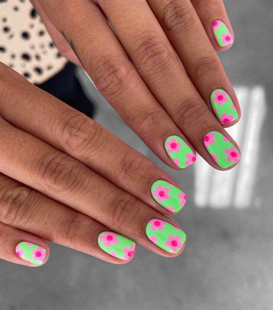 Vibrant Pink Florals on Lush Green Nails